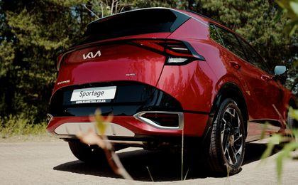 Red Kia Sportage 3/4 Back view near a forrest